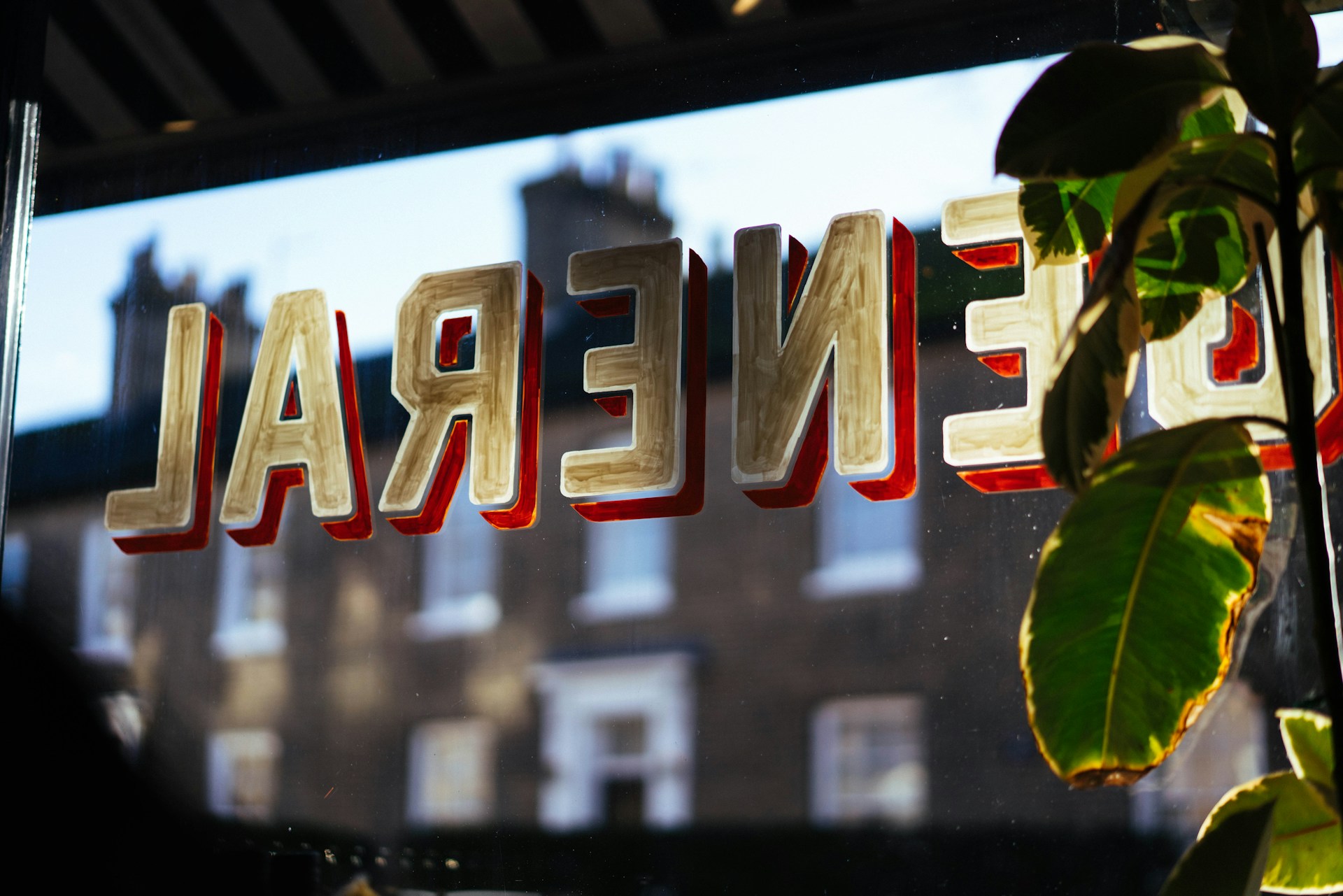Inside of a shop window showing a painted word displayed backwards