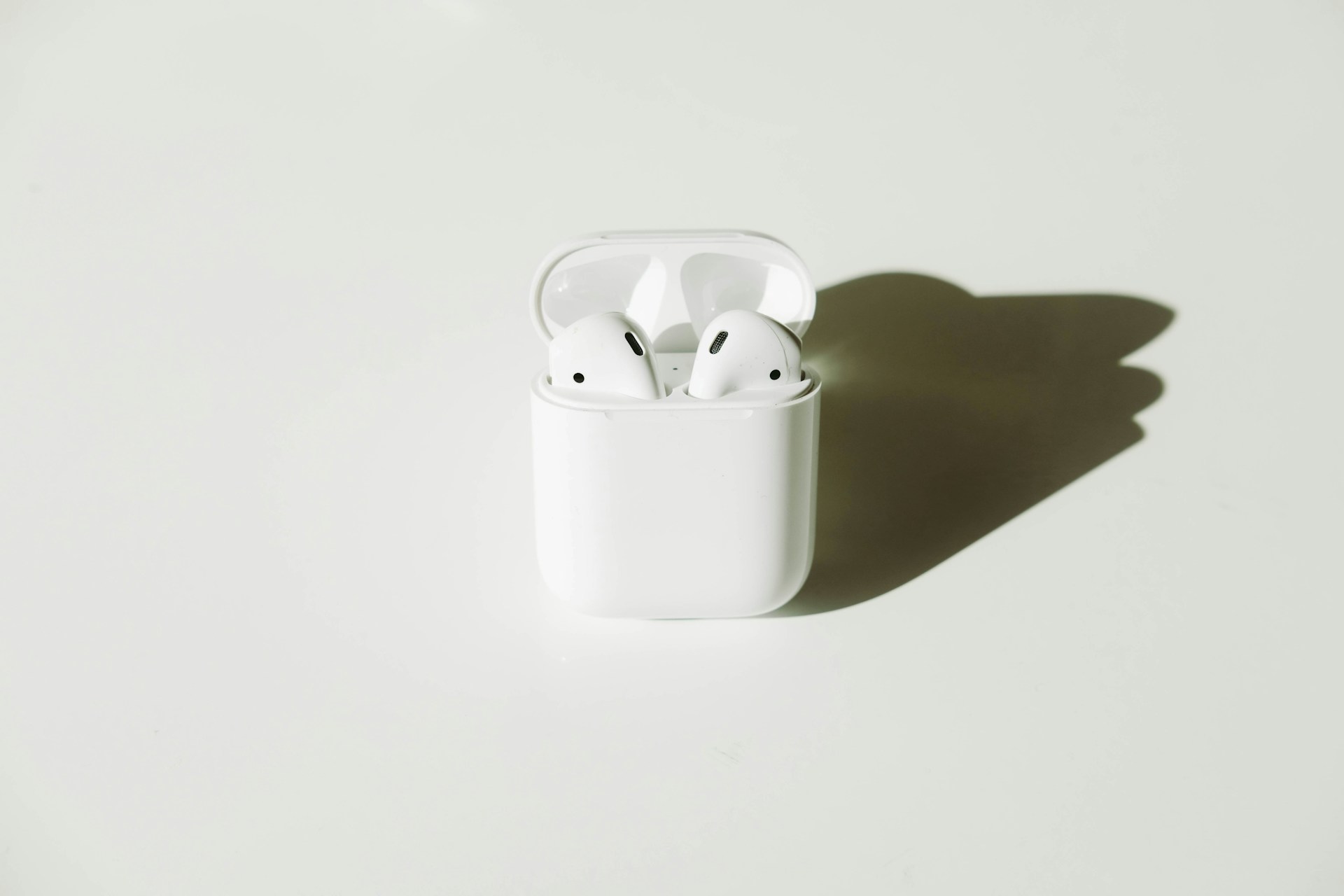Airpods in a case, with a shadow