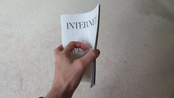 Gif of a hand flicking through the INTERNET OPERATOR zine, showing highlighted sections