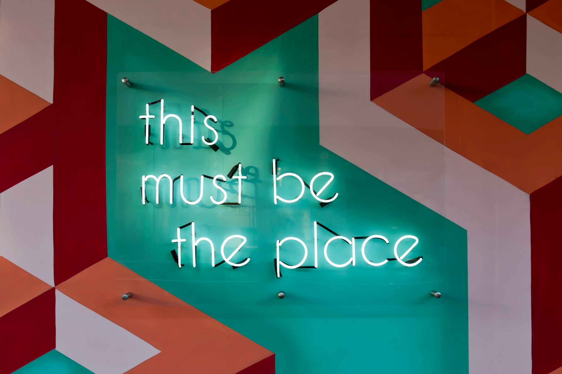 A neon sign reading 'this must be the place'