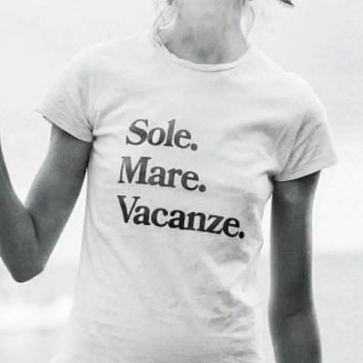 Black and white photo of someone wearing a t-shirt with the words 'Solo. Mare. Vacanze.' (which means Sun. Sea. Holidays. in English