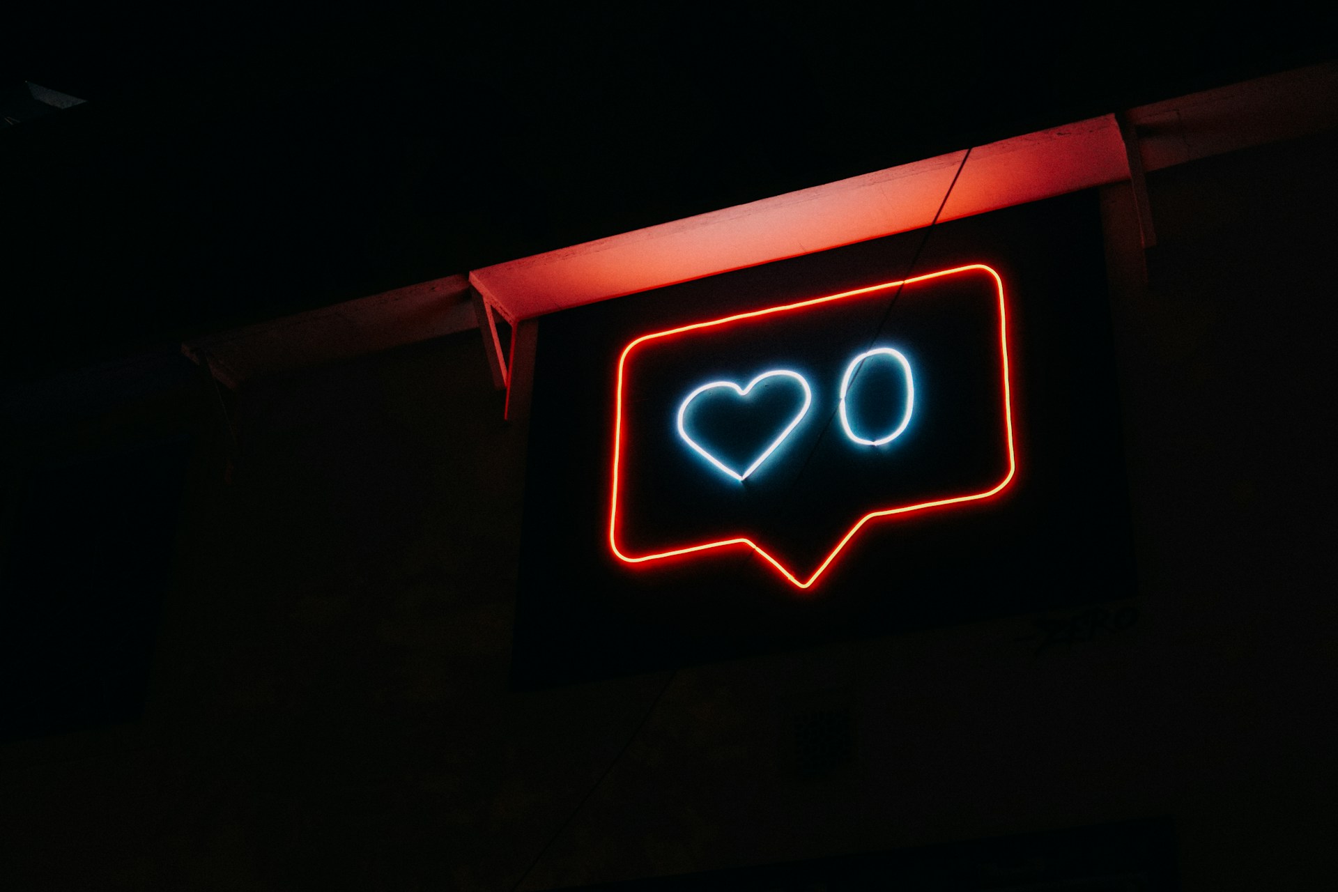 Dark room with LED sign showing 'like' symbol with a zero inside it