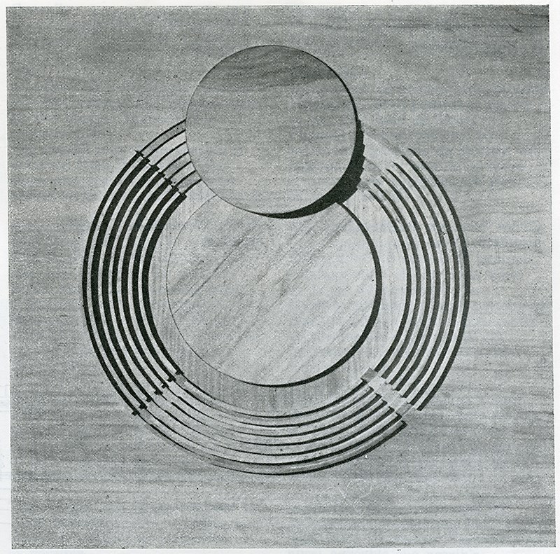 Abstract geometric composition showing two overlapping circles with the larger circle surrounded by concentric segmented rings broken at four radial gaps, evoking a target, coil, or schematic cross-section with the smaller circle partially covering the top.