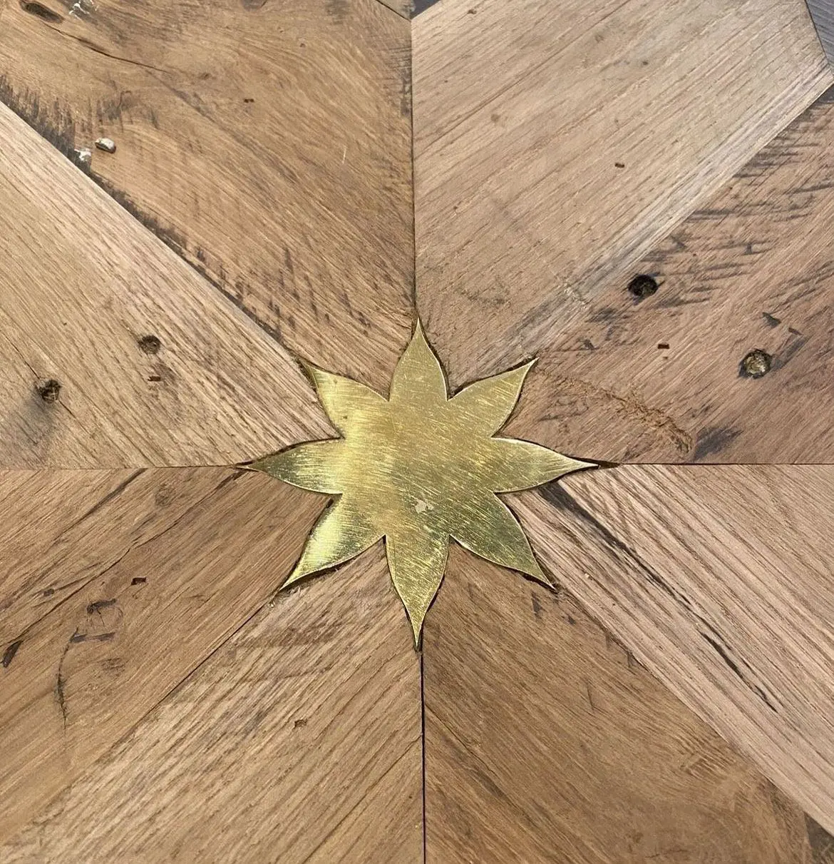Brass star connecting many parts of a wooden floor